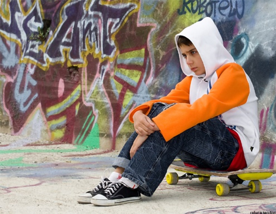  Stock photo of a teenager sitting on a skateboard