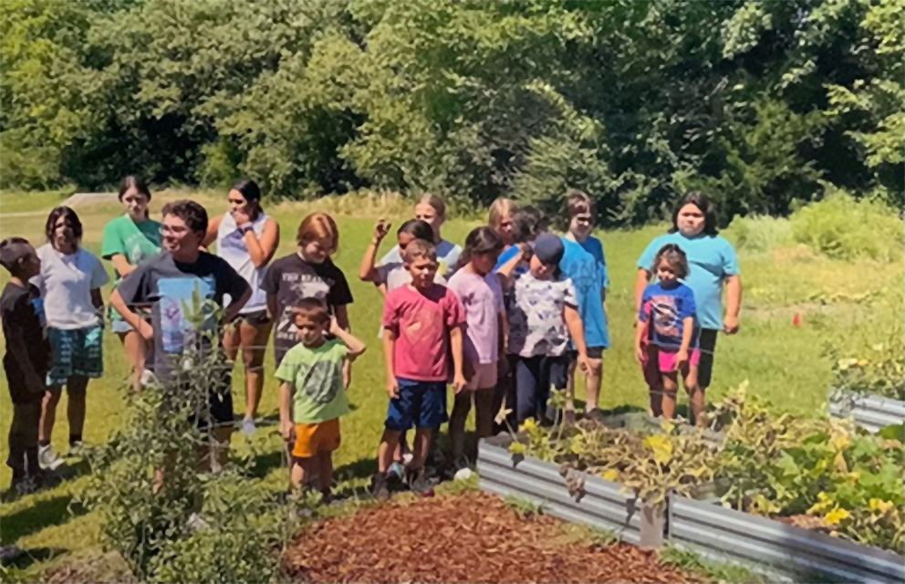 Photo of campers standing next to a garden at Camp Nikoti
