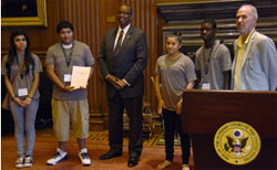 OJJDP Administrator Robert L. Listenbee with (left to right) student ambassadors Nancy Guandique, Johnnie Baites III, Catalina Quintana, and Justin Bronson. National Campaign to Stop Violence chairman Daniel Q. Callister stands behind the podium.
