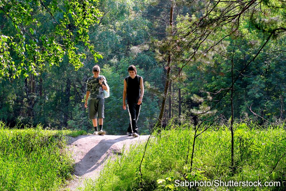 photo of two teenagers walking in the park