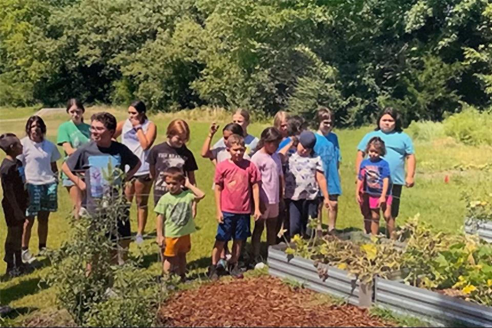 Photo of campers standing next to a garden at Camp Nikoti