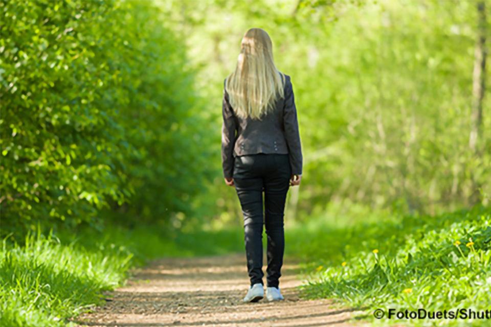 Stock photo of a young woman approaching an outdoor path