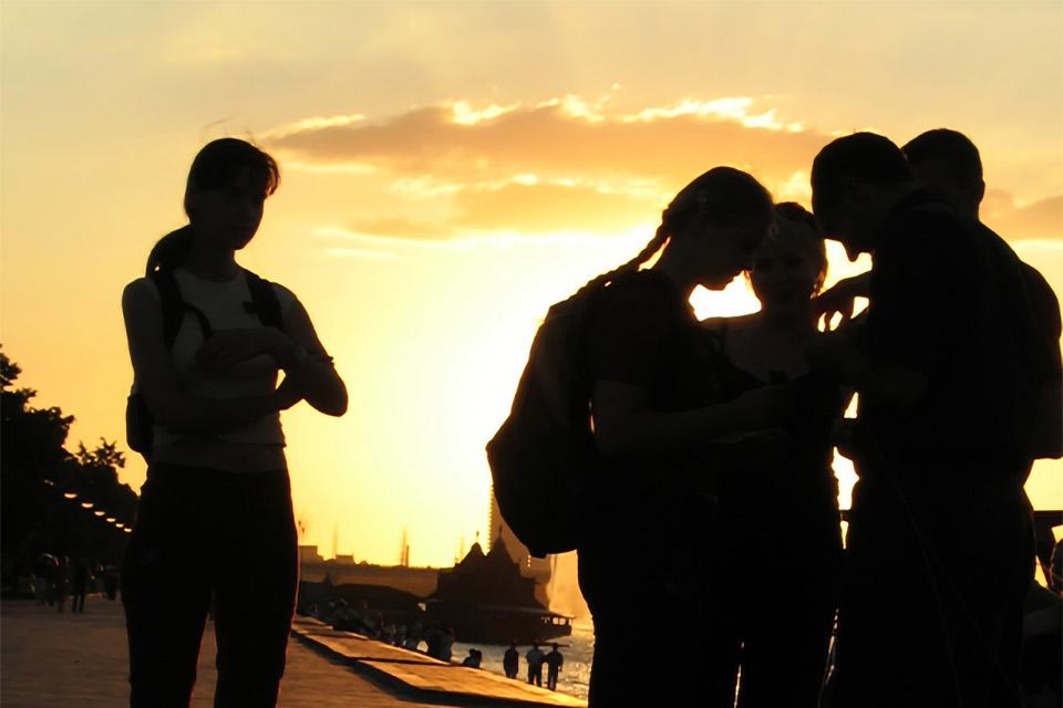 Stock photo of a small group of young people seen in silhouette during sunset 